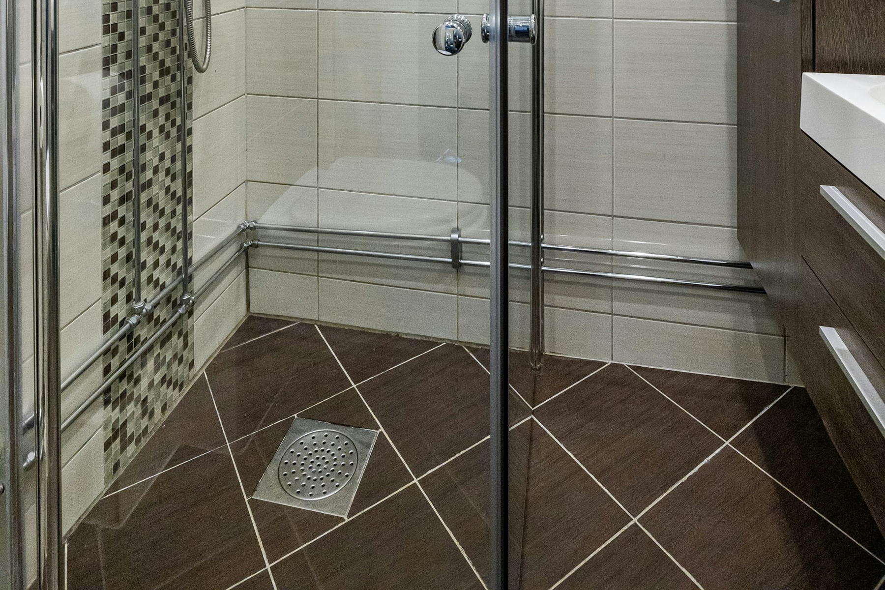 Duschabfluss in einer gefliesten Dusche von oben